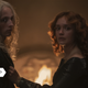 Aegon the Second and Queen Alicent, standing in front of a fire and glaring at Rhaenyra.